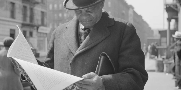 Marcus Garveyite reading the OWI Office of War Information publication "Negroes and the War," April 1943.